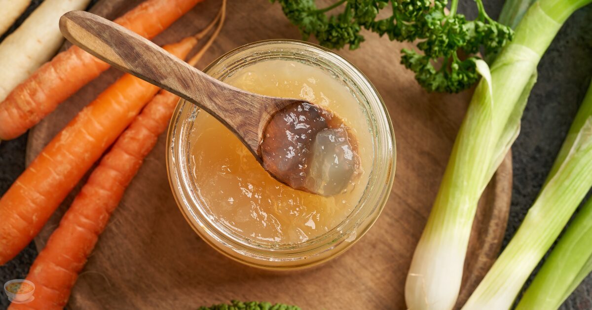 broth in a bowl with some vegetable ingredients around it